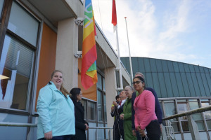 Hijsen van de regenboogvlag op CominOutDay